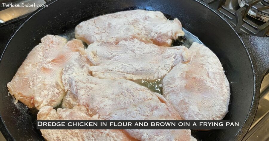 picture of floured chicken on a caast iron frying pan