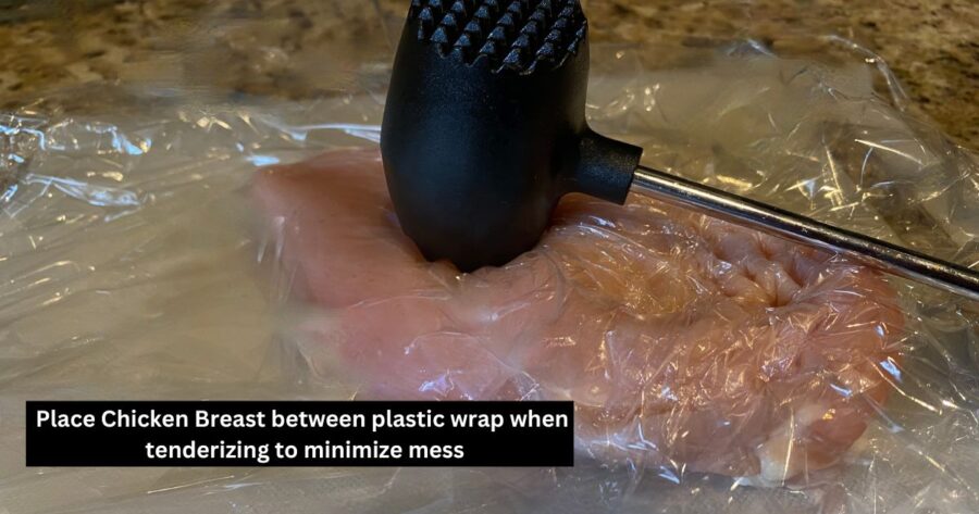 picture of chicken breast between layers of plastic wrap and meat tenderizer